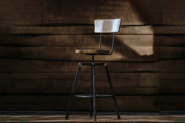 Tall bar stool on a wooden background