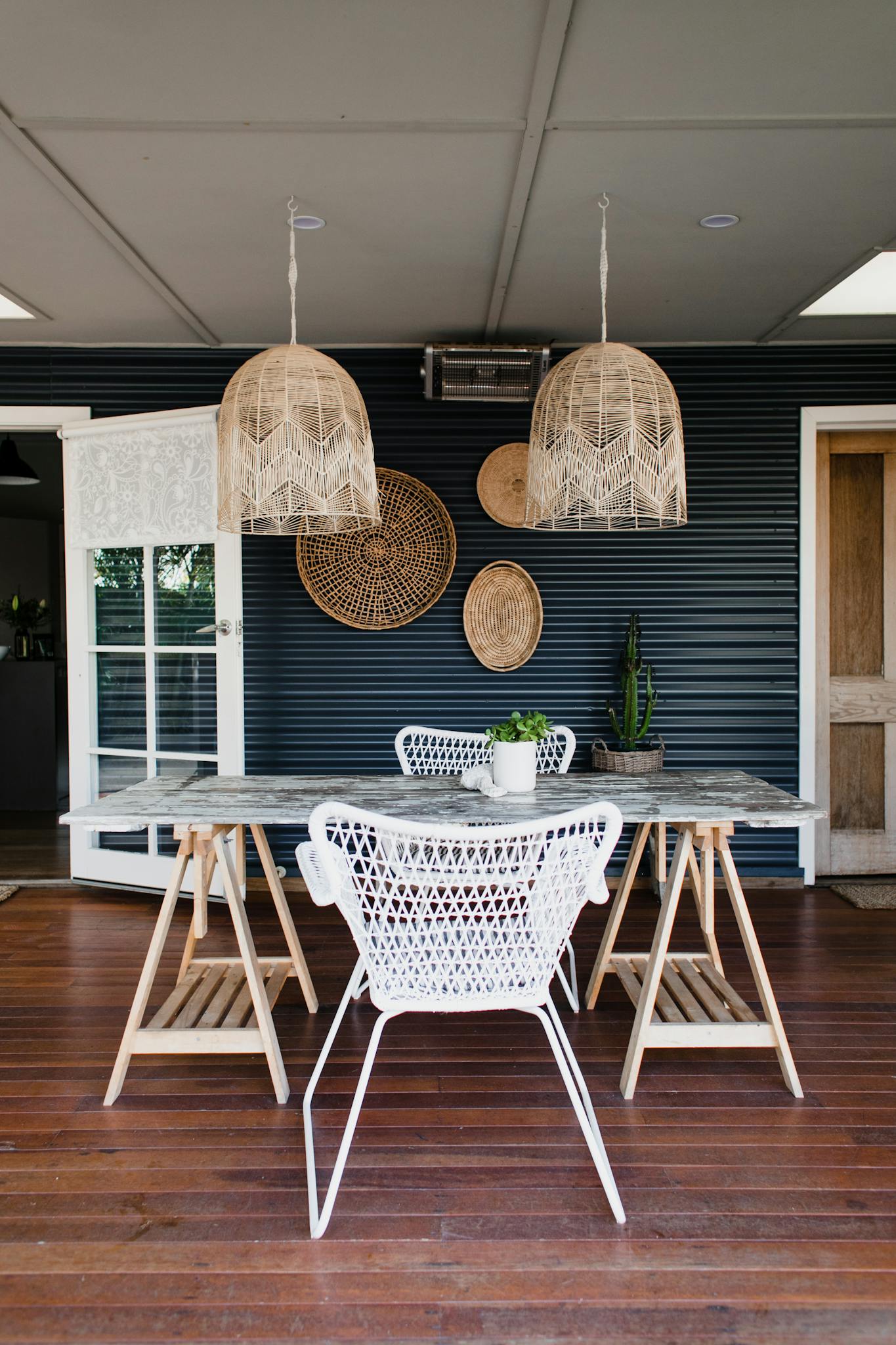 Modern dining space with wicker accents, wooden floor, and stylish hanging lamps for a cozy interior.